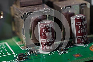 Close-up view of capacitors on a green printed circuit board (PCB