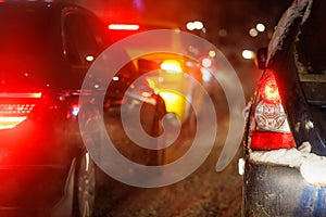 close-up view of car tail light and right turn signal at winter night traffic jam