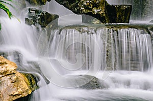 Close up view of cascading water falling over the rocks at Longshan Buddhist temple in Taipei city, Taiwan