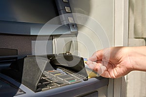 Close-up view of cash machine and woman`s hand with credit card