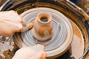 A close up view on ceramic production process on potter`s wheel with children. Clay crafts with kids concept