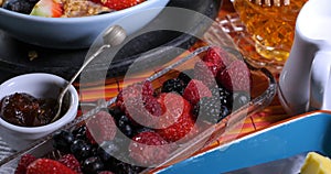 Close up view of cereals with berries, dry fruits and milk