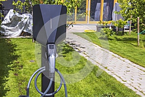 Close up view of charging station for electric car in front yard of townhouse.