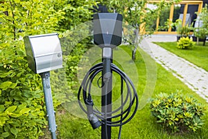 Close up view of charging station for electric car in front yard of townhouse.