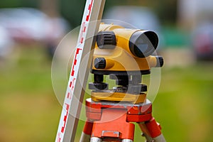 close-up view of cheap geodesy level device with tower ruler outdoors