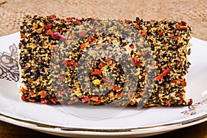 Close up view of a cheese roll with spices on a white plate