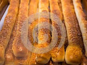 Close-up view of the chesse stick breads on a tray and selling in the bakery shop