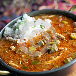 Close up view of chicken and Andouille sausage gumbo with a scoop of rice.