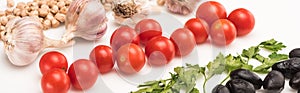 Close up view of chickpea, garlic, cherry tomatoes, parsley, olives on white background, panoramic shot.