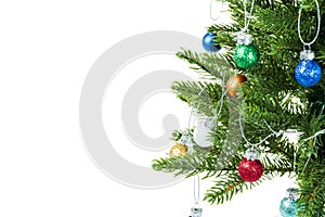 Close up view of Christmas fir tree branch with colorful balls isolated on white background.  Postcard.