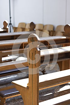 A close up view of a church bench lit by a sunray.