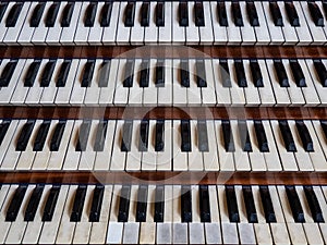 Close up view of a church pipe organ with four keyboards