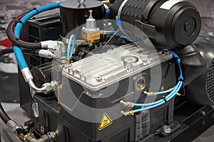 Close up view on clean new air compressor with electric motor, filter, rubber hoses, pneumatic and hydraulic components. Turbo com photo