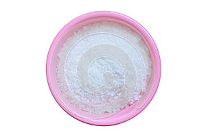 Close up view of coarse or natural sea salt in a pink bowl isolated on a white background