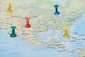 Close up view of colorful push pins on world map.
