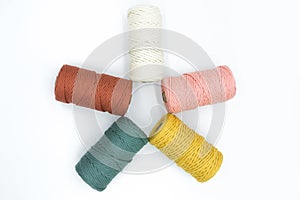 Close-up view of the colorful single strand cotton cords for macrame DIY handcraft on white background