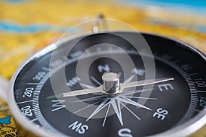 Close up view on compass and map in background