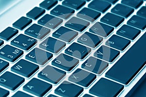 Close up view of a computer keyboard keys in blue tones