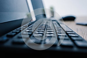 close up view of computer keyboard at table with computer mouse and laptop
