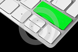 Close up view of a computer notebook keyboard with one green empty button isolated on black background. Technology background empt