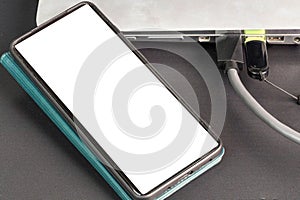 Close up view of  connecting usb cable  mobile phone with mockup image blank screens.