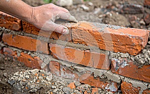 Close-up view of a construction worker& x27;s hand skillfully laying bricks, with focus on the detailed texture and