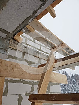 close-up view of corner of house with scaffolding, where preparatory work is carried out before covering roof of final roof