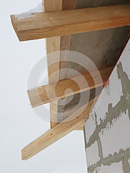 close-up view of corner of house with scaffolding, where preparatory work is carried out before covering roof of final roof