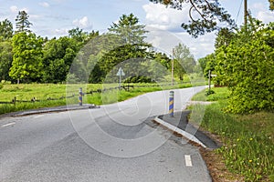 Close-up view of country road with speed limit by compulsion to slow download because of road narrows.