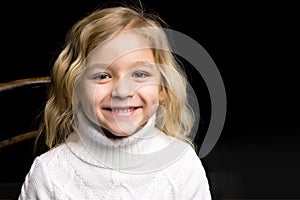 Close Up View of Cute Smiling Blonde Girl Posing on Black Backgr