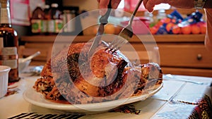 Close up view of Cutting Roasted Thanksgiving Turkey Dish With Knife During Dinner Celebrating Holiday At Home.