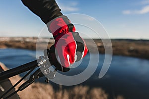 Close up view of a Cyclist equipment glove and handlebar. Man Riding the Bike Down Rocky Hill at Sunset. Extreme Sport Concept