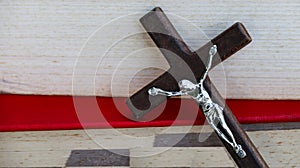 Close up view of dark brown wooden cross on old books with blur background