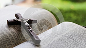 Close up view of dark brown wooden cross on old books with blur background