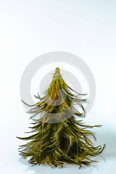 Close up view of decorative christmas tree made of rooster feathers isolated. Hobby concept