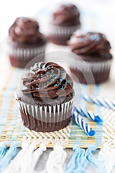 A close up view of delicious chocolate frosted chocolate cupcakes ready for eating.