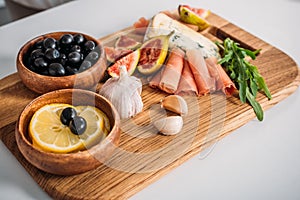 close-up view of delicious snacks on wooden board on table