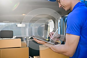 Close up view of delivery man checking package on tablet before sending to the customer