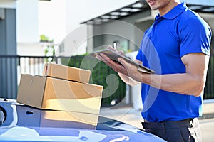 Close up view of delivery man checking package on tablet before sending to the customer