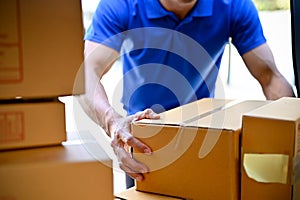 Close up view of delivery man organizing packages before handing package to customers