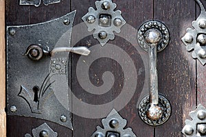 Close up view on detail of a old massive wooden door with metal shackles