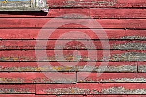 Close up view of deteriorating red siding on a 19th Century wooden barn