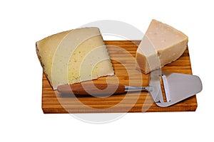 Close up view of different kinds of cheese with cheese knife isolated on wooden board. Healthy food concept