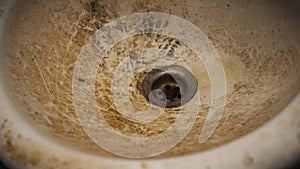 The close up view of the dirty stain inside of the toilet sink in the house. Yellow limescale stain