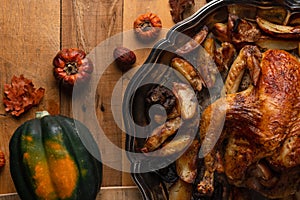 Close-up view of dish with baked turkey, potato and mushrooms on rustic wooden table with autumn harvest background. Thanksgiving