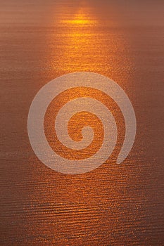 A dramatic orange sun way of reflections in water