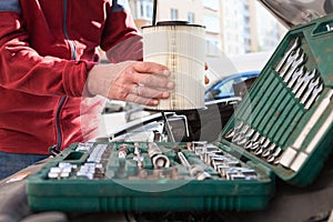 Close up view at driver hands with new clean air filter, replacing without any motor-service