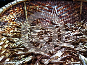 Close up view of dry fish on a bamboo woven tray for pickle preparation. photo