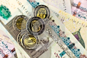 Close up view of Egyptian one pound coin on the background of Egyptian banknotes and coins