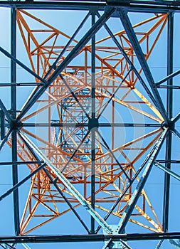Close-up view of an electric tower with a beautiful blue sky background. Industrial engineering concept. Iron structure for high-